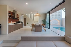Une cuisine moderne avec un coin repas, un escalier et une vue sur la piscine.