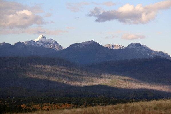 A mountain landscape with a prominent peak and forested valleys.