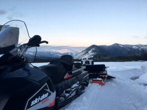 A snowmobile with a 'SKI-doo' label, tracks, and a trailer.