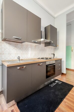 Eine moderne Küche mit einer zentralen Kochinsel, einem eingebauten Backofen und Edelstahlgeräten.
