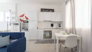 Um espaço compacto com cozinha compacta, área de refeições e sofá.