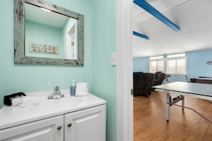 Une salle de bain avec un meuble-lavabo blanc, un miroir et un porte-serviettes.