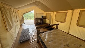 Ein Zelt mit Bett, Tisch und Stuhl.