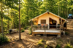 Una cabaña de madera rústica con un porche, rodeada de un bosque.