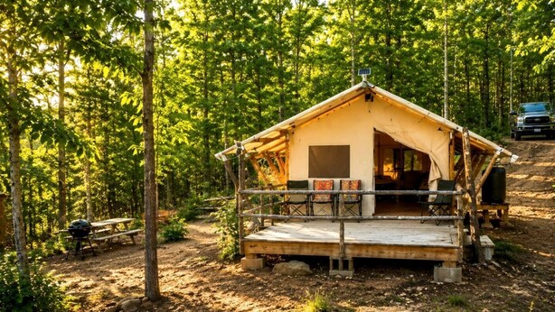 Ein rustikales Holzhaus mit einer Terrasse, umgeben von einem Wald.