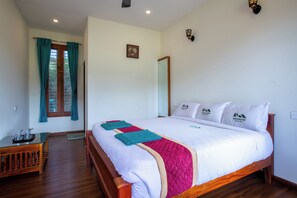 Un dormitorio con cama de madera, mesita de noche, ventana con cortinas y lámpara de pared.
