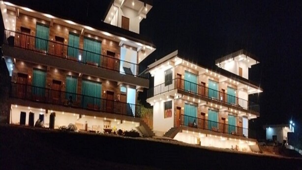 Un hotel de varios pisos con balcones, techo plano y fachada bien iluminada.