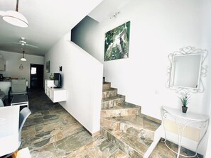 Ein modernes Interieur mit einer Treppe, einem Essbereich und einer Küche.