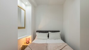 A bedroom with a bed, bedside lamp, and a mirror on the wall. - Rećina, Studio apartment near Žnjan Beach (Split)
