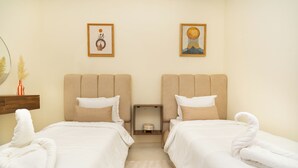 A hotel room with two beds, a nightstand, a mirror, and two framed pictures on the wall. - Luxury apartment complex with a pool and gym, 10 minutes from Guéliz (marrakech)