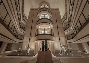 A modern interior with a central staircase, reflective surfaces, and a symmetrical design. - Xiamen Lanyue Fliport Hotel (Xiamen)
