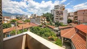 Zona residencial con una mezcla de edificios modernos y tradicionales, cielo despejado y un balcón con vistas al vecindario.