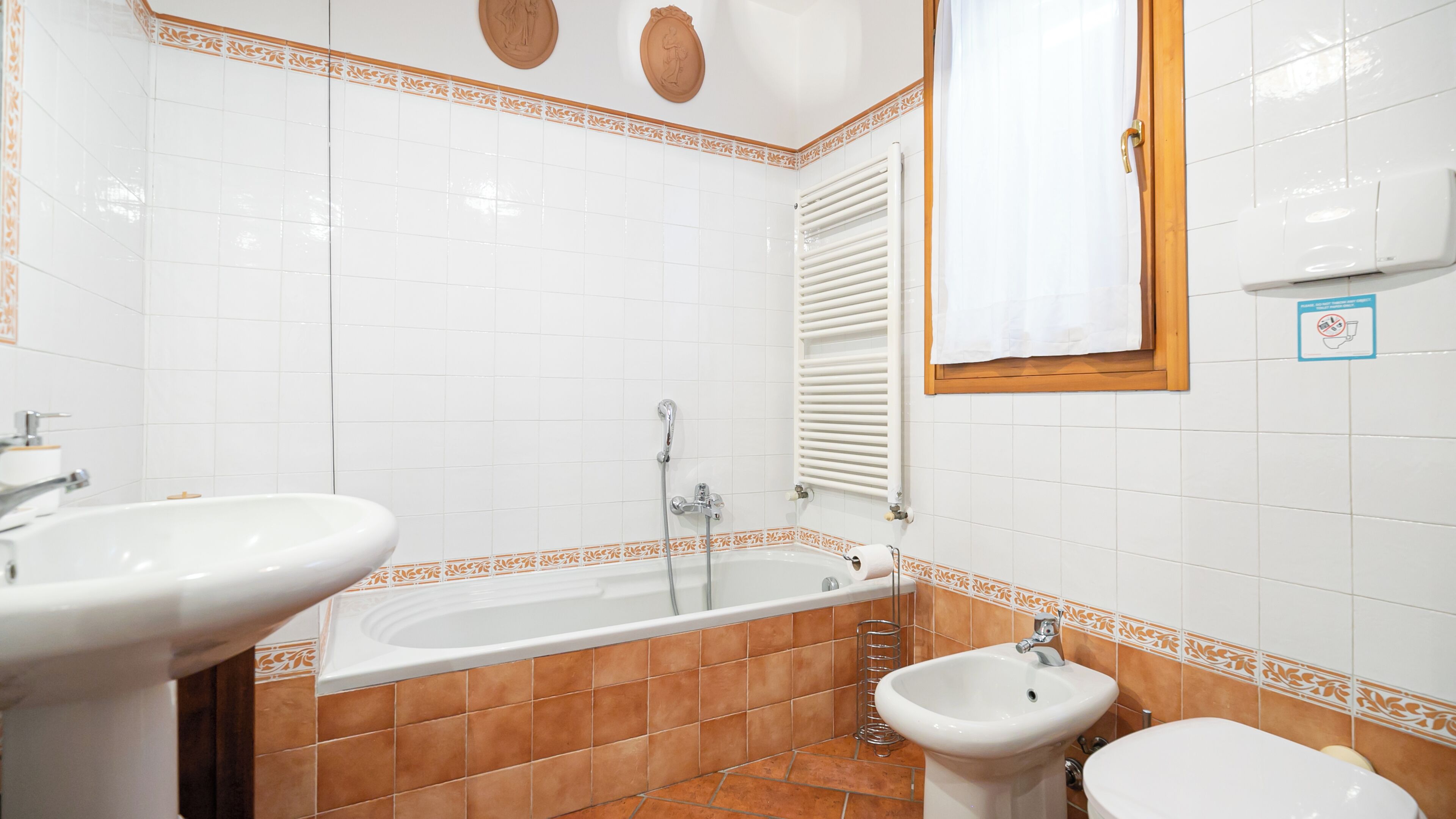 A bathroom with a bathtub, two sinks, and a bidet.