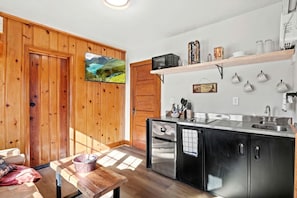 Une cuisine moderne avec des murs en bois, un four encastré et une grande fenêtre.