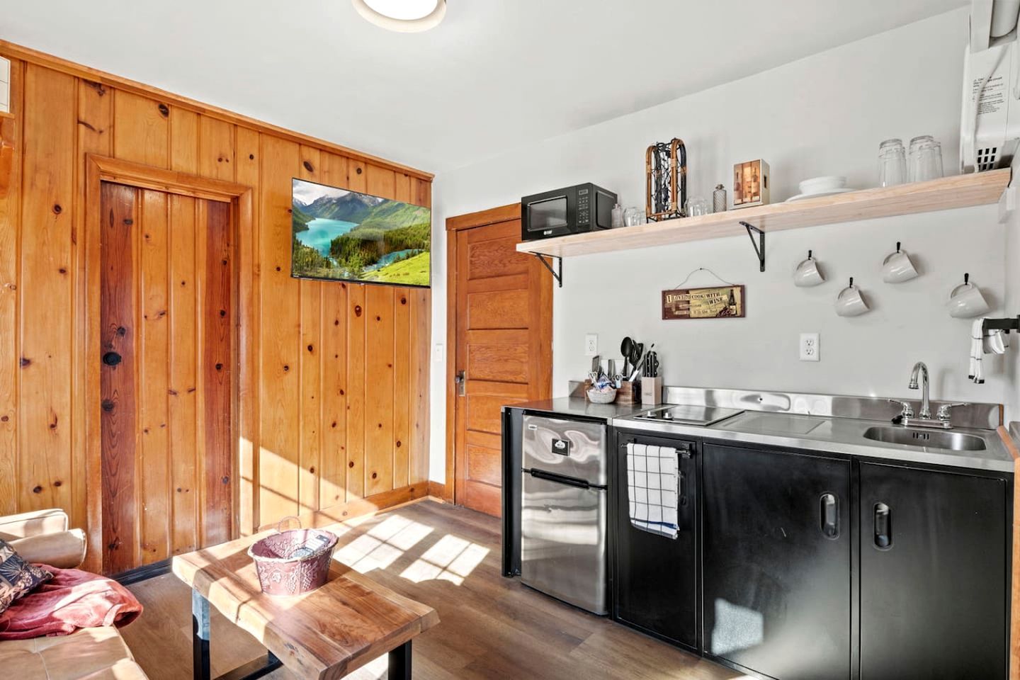 Une cuisine moderne avec des murs en bois, un four encastré et une grande fenêtre.