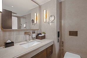 A modern bathroom with two sinks, a large mirror, and a handheld showerhead. - Fortune Select Lucknow (Lucknow)