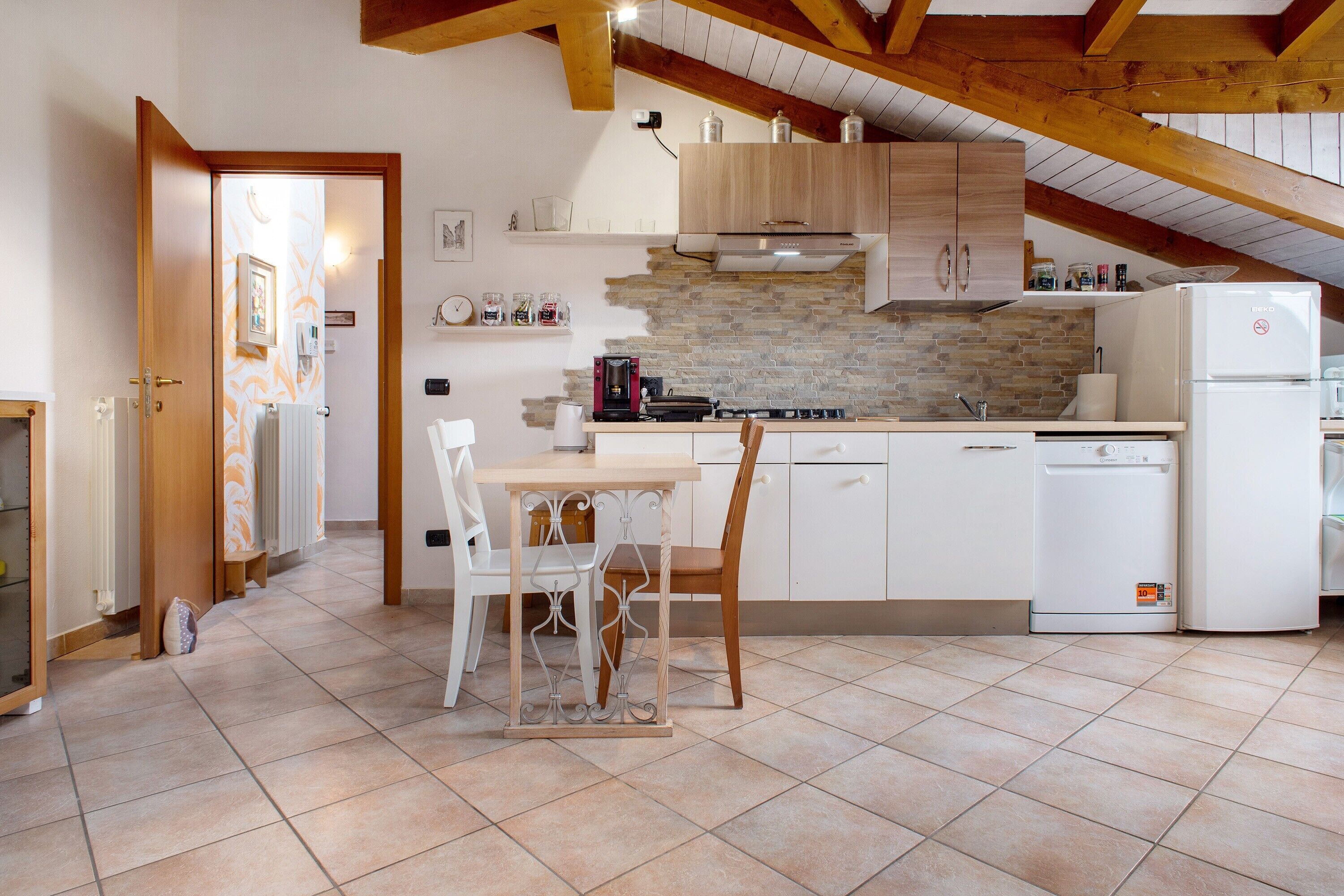 A kitchen with a dining table, chairs, a refrigerator, and a stove.