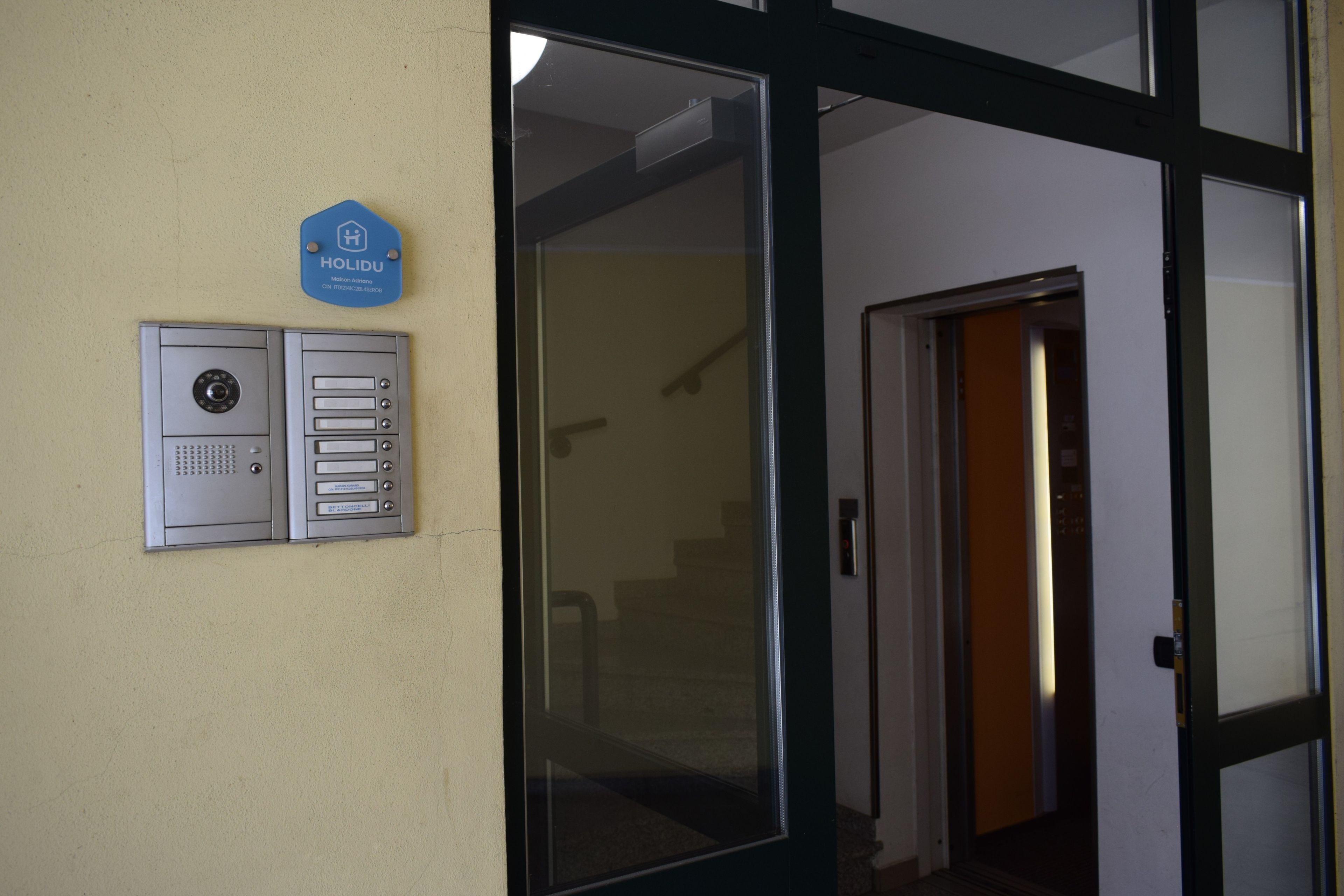 L’entrée d’un hôtel, dotée d’un système d’interphone de sécurité et d’une enseigne bleue au-dessus.
