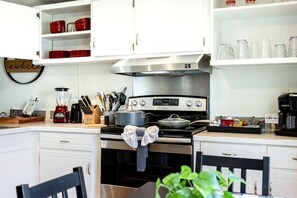 A kitchen with white cabinets, a stove, a coffee maker, and a sign that reads 'Welcome to the coffee nook.' - Amazing Vacation Rental in Sabine National Forest on Toledo Bend Lake for a Fantastic Family Escape in Hemphill, Texas (Hemphill)