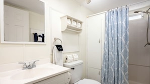 A bathroom with a white sink, toilet, and shower curtain. - Amazing Vacation Rental in Sabine National Forest on Toledo Bend Lake for a Fantastic Family Escape in Hemphill, Texas (Hemphill)