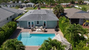 A residential area with a swimming pool, houses, and palm trees. - Private Tropical Oasis • Heated/Cooled Pool (Naples)