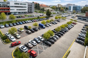 A multi-story parking structure with rows of parked cars and a few trees. - Hotel Bratislava (Bratislava)