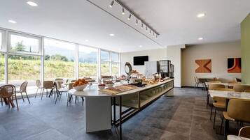 Un comedor moderno con barra libre, ventanas amplias y vistas al exterior.