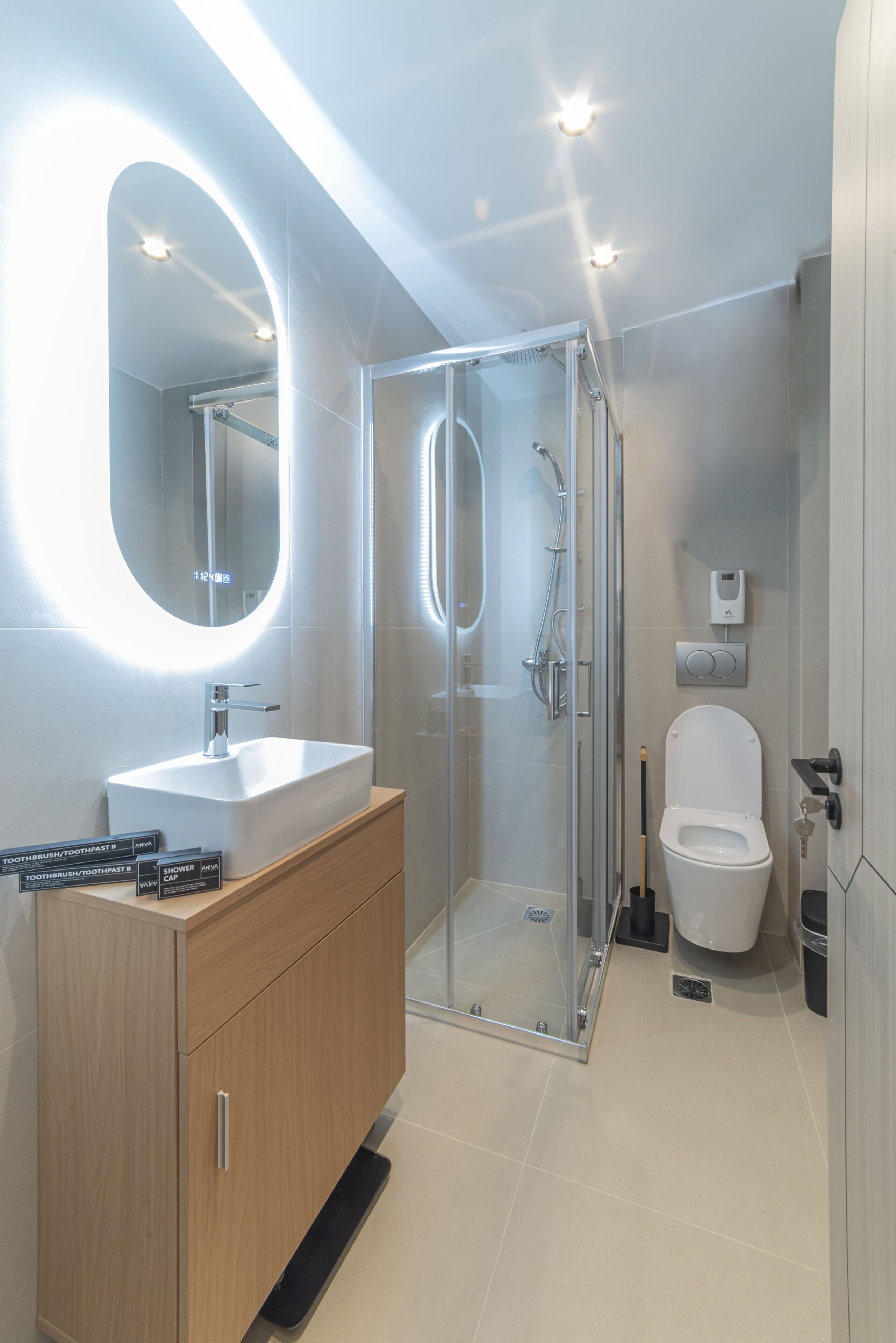 Une salle de bain moderne avec une douche à parois de verre, un meuble-lavabo en bois et des toilettes.