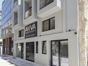 A modern building with a sign reading 'AKVA PROPERTY THE PIRAEUS COLLECTION'.