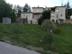 A residential building with a stone facade, multiple windows, and a balcony.
