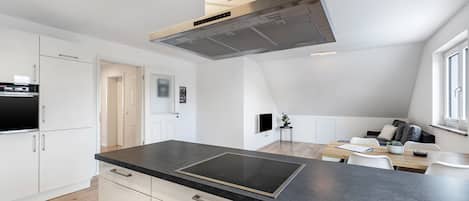 Eine moderne Küche mit schwarzem Arbeitsplatz, Edelstahlgeräten und einem eingebauten Backofen.