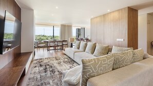 Una sala de estar moderna con un sofá, televisor y comedor.