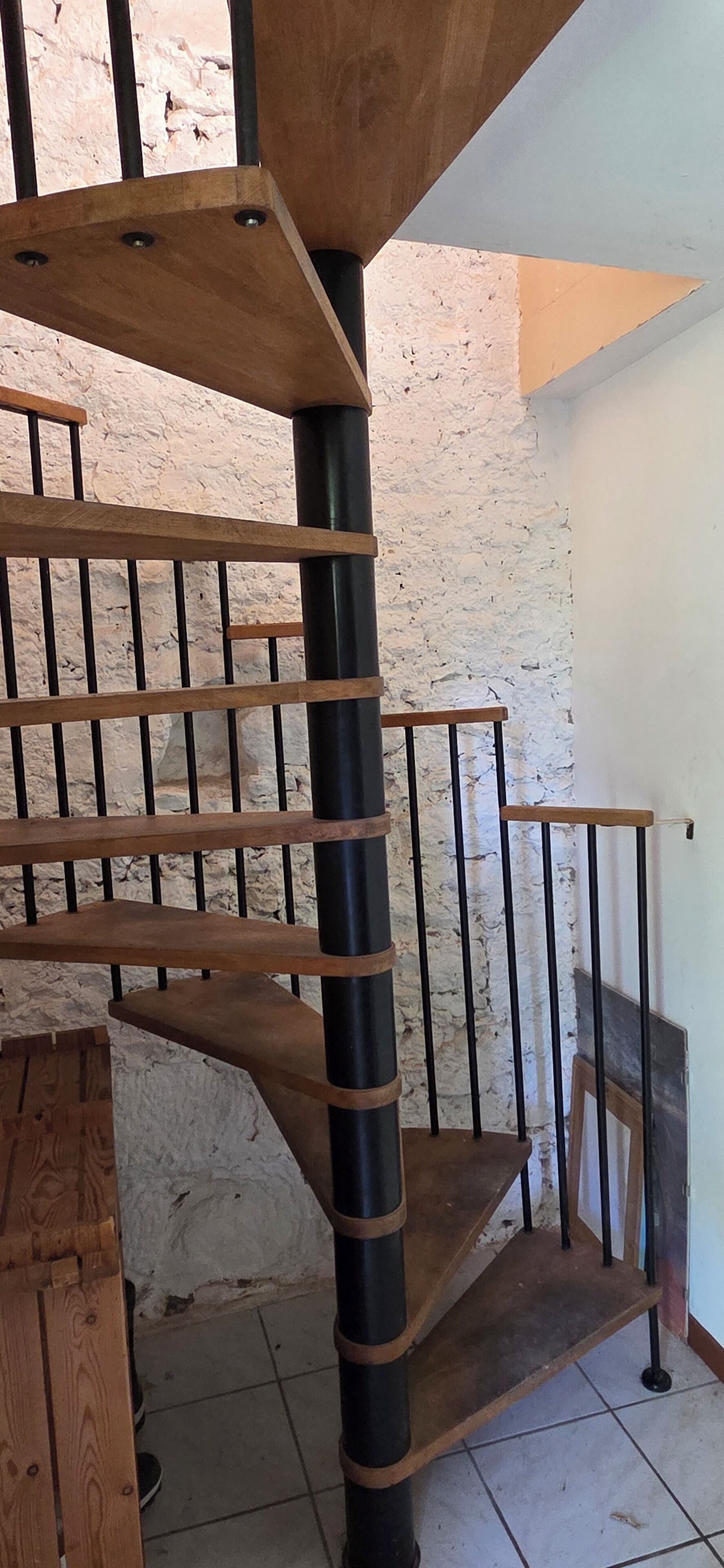 A spiral staircase with wooden steps and metal railings.