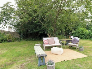 A garden with a bench, a table, and two chairs. - The Farmhouse (Langport)