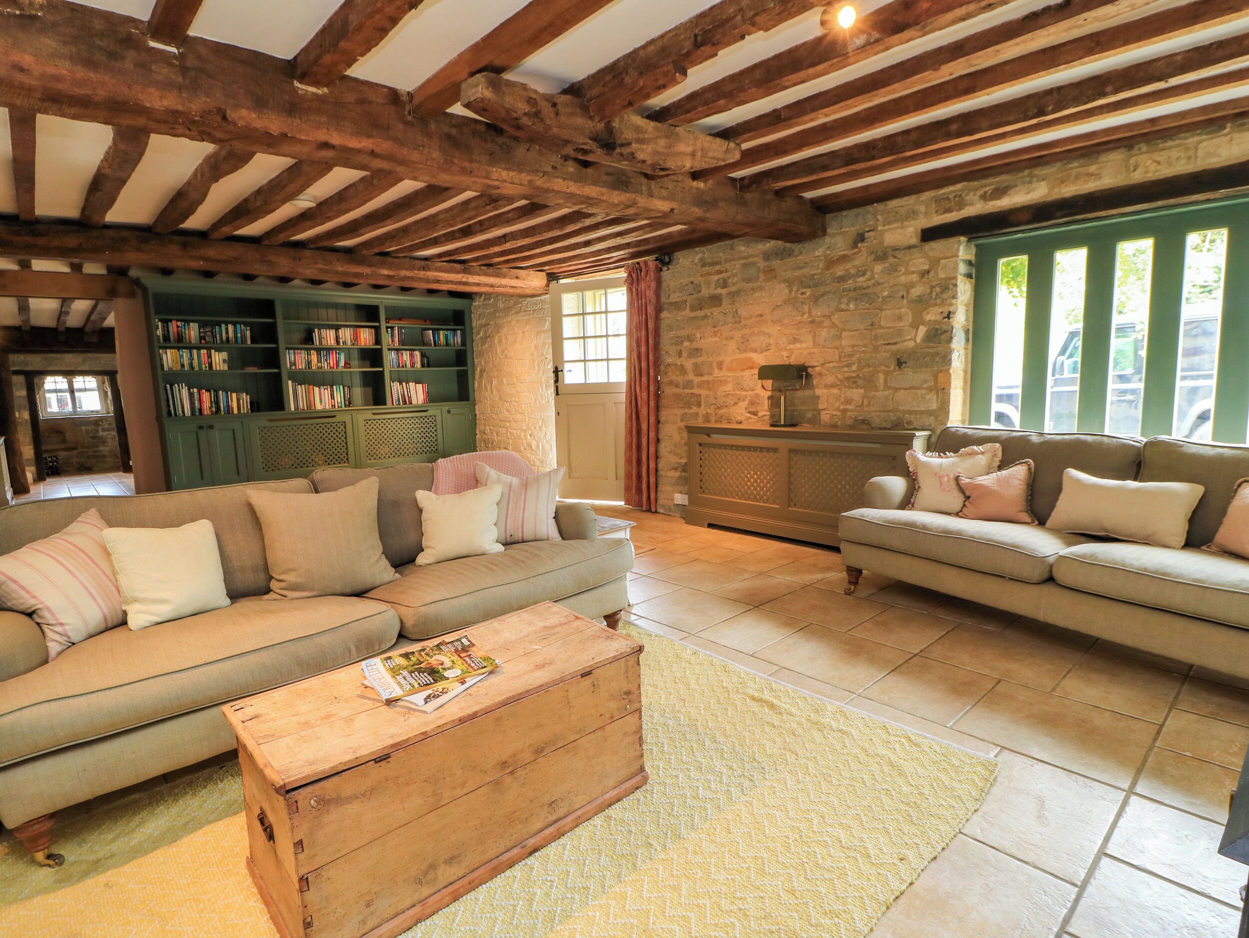 A cozy living room with a sofa, a wooden coffee table, and a bookshelf.