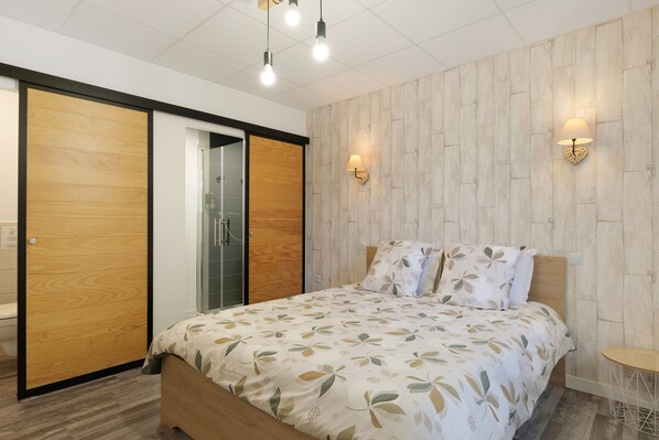 A bedroom with a bed, wooden wardrobe, and two wall-mounted lamps. - Guest Room “L'Etoile” with Shared Terrace and Garden, Wi-Fi (Romillé)