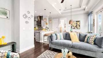 A modern living room with a grey sofa, a coffee table, and a ceiling fan.