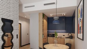 A modern kitchen with a microwave, kettle, and a hanging pendant light. - Cobalt36 (Bolesławiec)