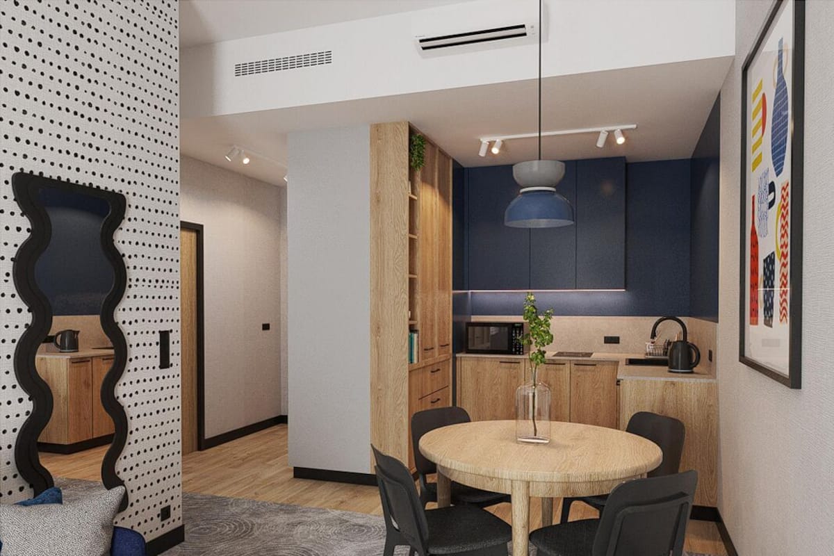 Una cocina moderna con microondas, hervidor y una lámpara colgante.