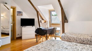 A bedroom with a bed, a TV, a desk with chairs, and a window. - Guest Room “Le clair de Lune” with Shared Terrace & Garden, Wi-Fi (Romillé)
