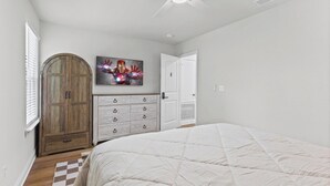 A bedroom with a bed, a wardrobe, a door, and a ceiling fan. - The Compound (Mobile)