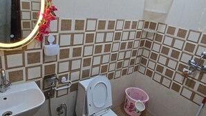 Un baño con inodoro, lavamanos y espejo decorado con motivos florales.