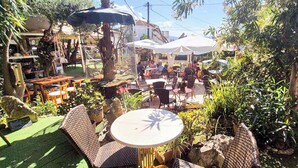 An outdoor patio with wicker furniture, umbrellas, and potted plants. - Bicorna Chania Pool Escape - Yellow Room 1 (Plaka)