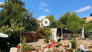 A swimming pool with a stone wall and greenery around it. - Bicorna Chania Pool Escape - Yellow Room 1 (Plaka)