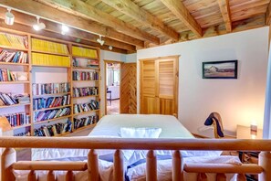 A bedroom with a bed, wooden bookshelves, a wardrobe, and a framed picture on the wall. - Warm & Inviting Cabin Retreat Perfect for Year-Round Escapes in Denver, New York (Denver)