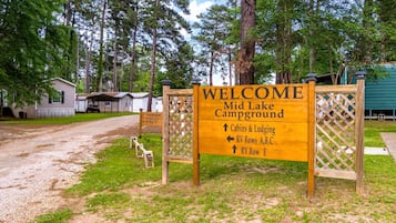 A campground sign with directions to cabins, RV rows, and a lodge.
