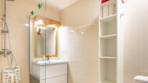 Une salle de bain avec une douche, un lavabo, un miroir et des toilettes.