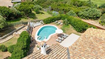 Une piscine sur le toit offrant une vue dégagée sur les environs, notamment sur un court de tennis et une végétation luxuriante.