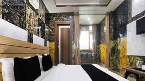 Una camera d'albergo con un letto grande, una testiera in legno, una TV e vista sull'esterno.