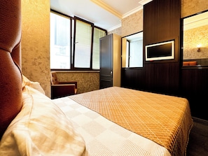 A hotel room with a bed, a television, and a window with blinds. - TAKSIM CUENTO HOTEL (İstanbul)
